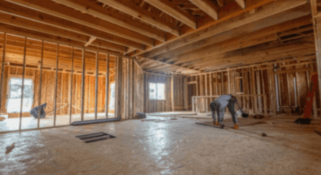 Worker framing interior construction site: how to choose the right custom home builder in Billings.